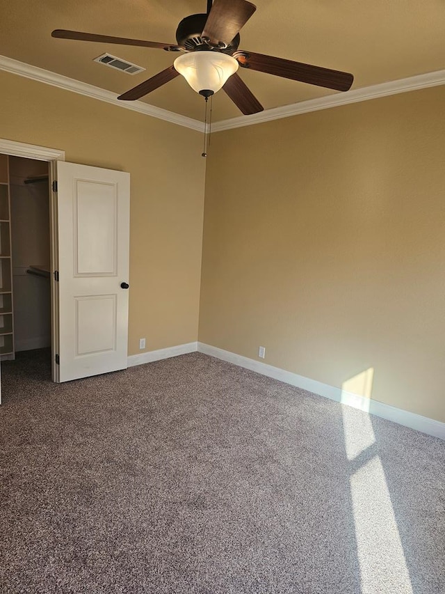 unfurnished bedroom featuring crown molding, a spacious closet, and a closet