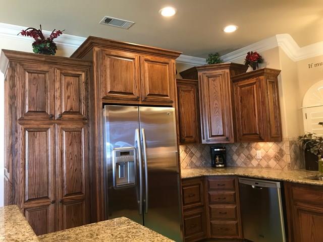 kitchen featuring stainless steel appliances, tasteful backsplash, light stone countertops, and crown molding