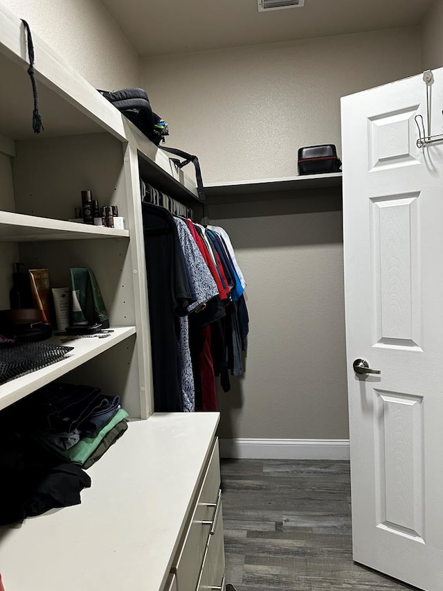 spacious closet with dark wood-type flooring