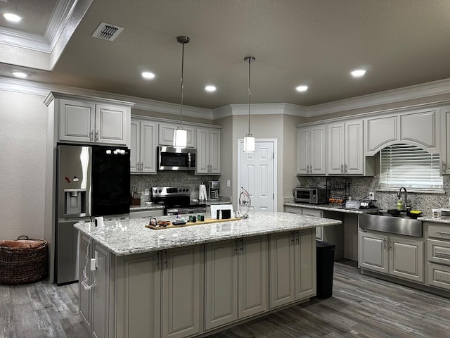 kitchen featuring a center island with sink, gray cabinetry, sink, and appliances with stainless steel finishes