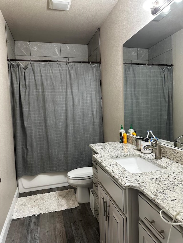 bathroom with walk in shower, hardwood / wood-style floors, a textured ceiling, toilet, and vanity