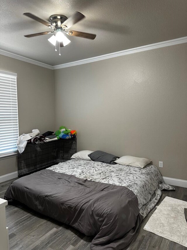 bedroom featuring ornamental molding, ceiling fan, and dark wood-type flooring