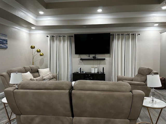 living room with hardwood / wood-style flooring, a raised ceiling, and crown molding