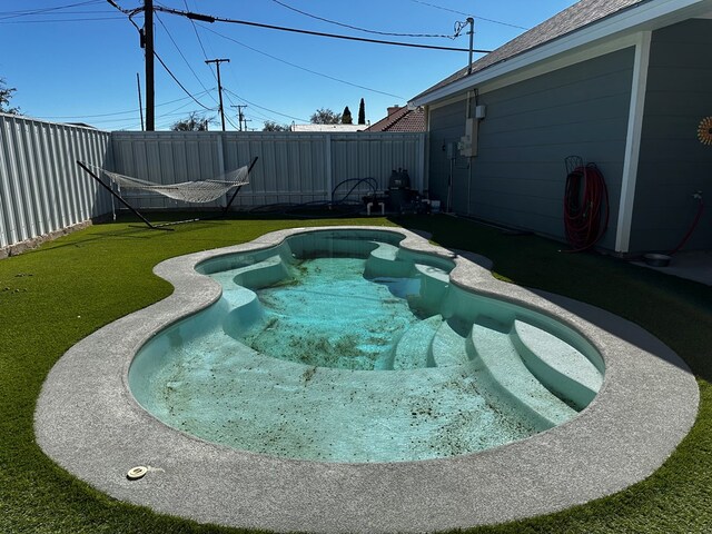 view of swimming pool featuring a lawn