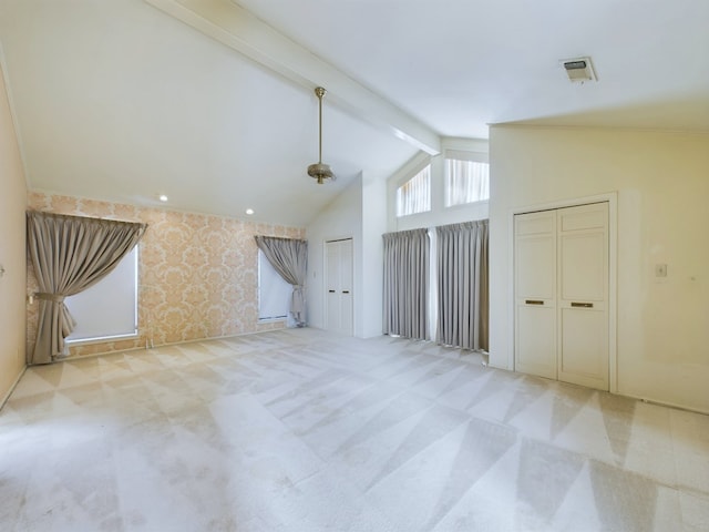 carpeted spare room featuring vaulted ceiling with beams