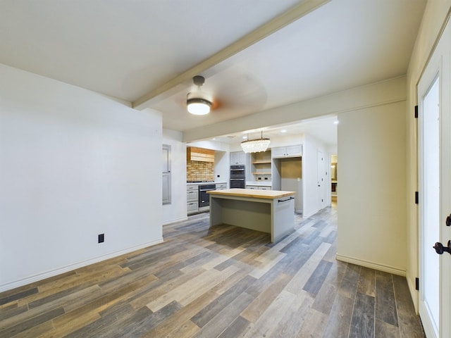 kitchen featuring a center island, a kitchen breakfast bar, dark hardwood / wood-style floors, decorative light fixtures, and white cabinetry