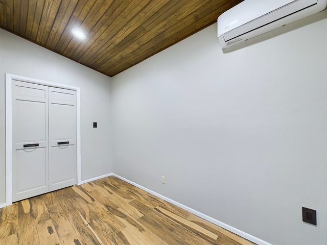 unfurnished room featuring hardwood / wood-style floors, vaulted ceiling, a wall unit AC, and wood ceiling