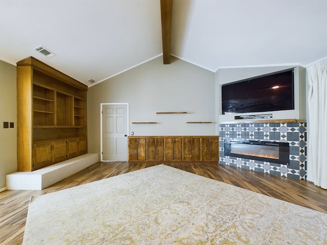 unfurnished living room featuring vaulted ceiling with beams, a tiled fireplace, and hardwood / wood-style flooring