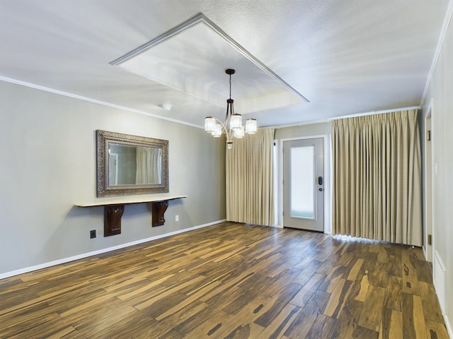 empty room featuring a textured ceiling, dark hardwood / wood-style flooring, crown molding, and a chandelier