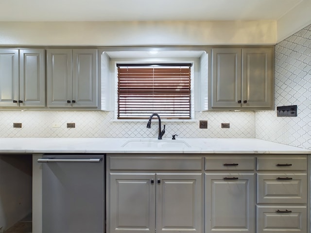 kitchen featuring gray cabinetry, decorative backsplash, dishwasher, and sink