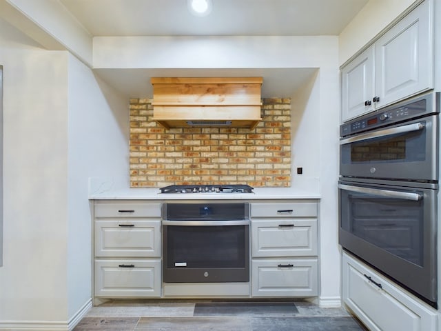 kitchen featuring white cabinets, decorative backsplash, and stainless steel appliances