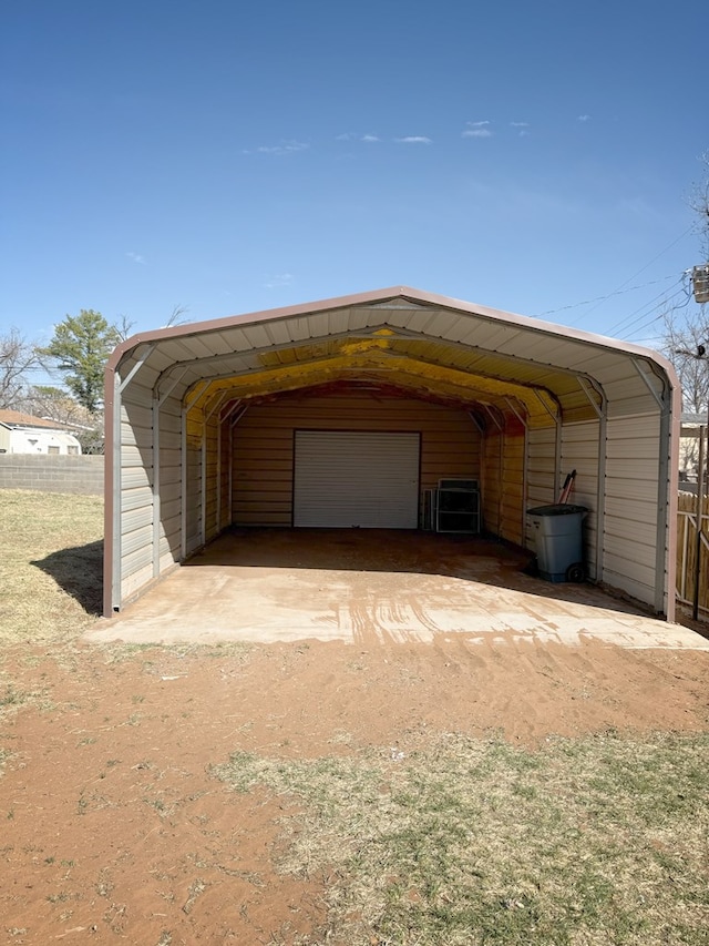 exterior space featuring a detached garage and fence