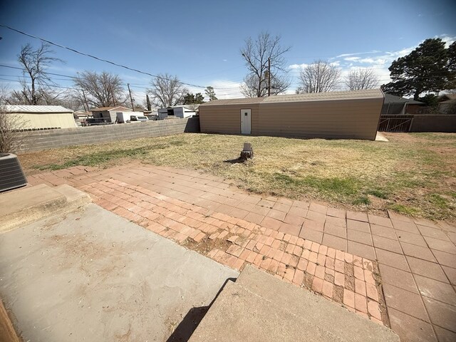 view of yard featuring a patio, central air condition unit, and fence