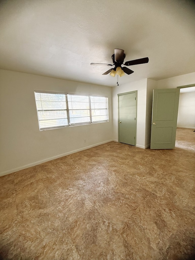 unfurnished bedroom featuring a ceiling fan and baseboards