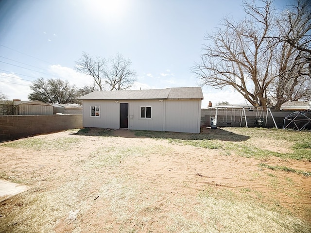 rear view of house with an outbuilding and fence