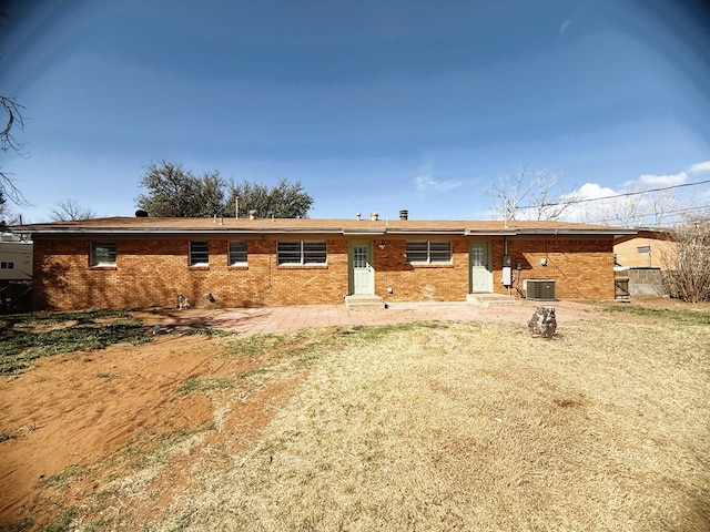 back of property with a patio, brick siding, central AC, and entry steps