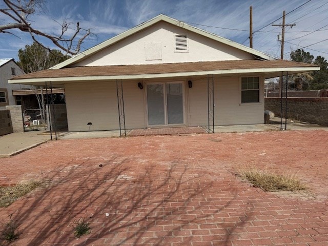 rear view of house featuring fence