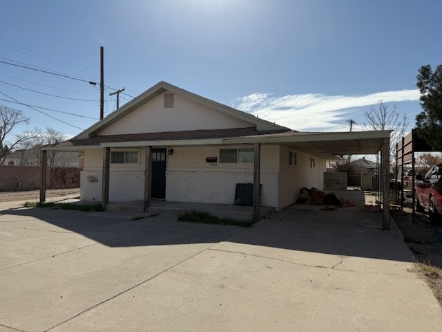 view of front of house with driveway, an attached carport, and brick siding