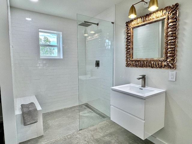 bathroom with a tile shower and vanity