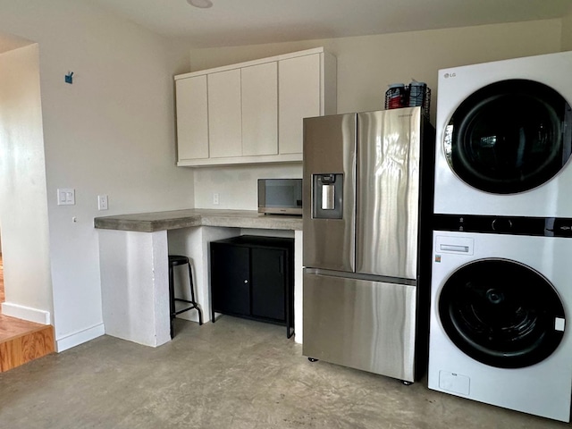 clothes washing area with stacked washer and clothes dryer