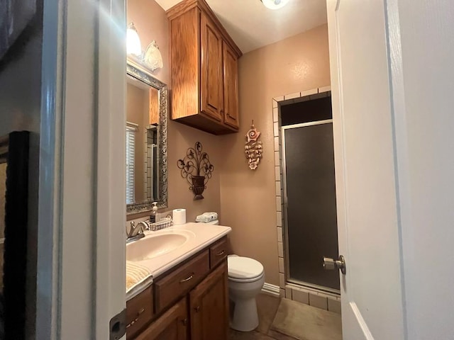 bathroom with tile patterned floors, vanity, toilet, and walk in shower