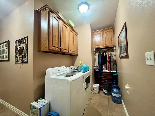 laundry area featuring light tile patterned floors, cabinets, and independent washer and dryer