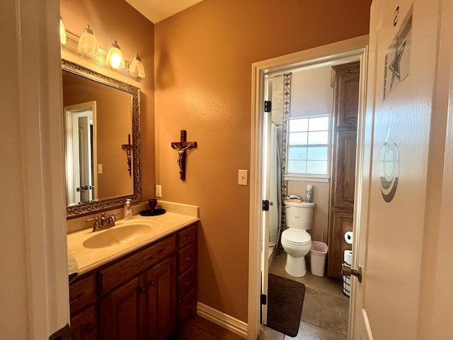 bathroom with tile patterned flooring, vanity, and toilet