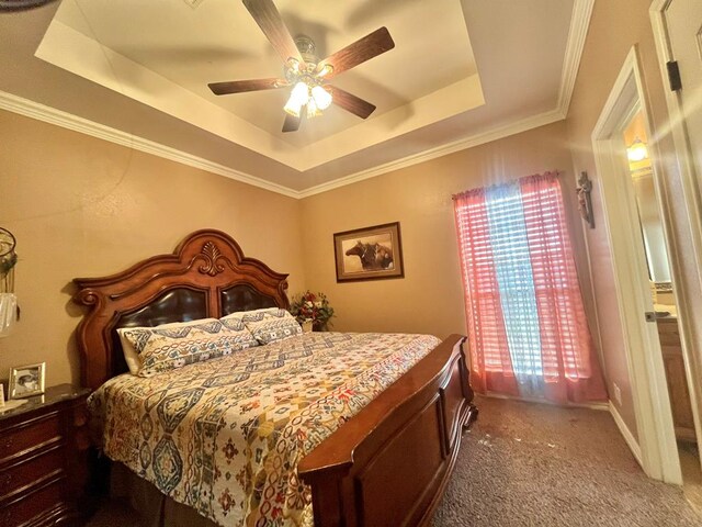 bedroom featuring ceiling fan, carpet floors, ornamental molding, and a tray ceiling