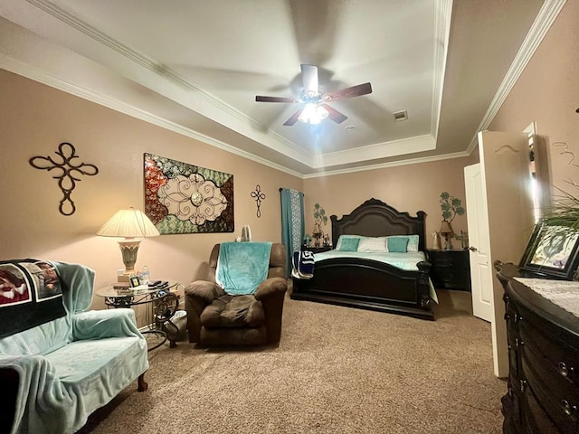 carpeted bedroom with a tray ceiling, ceiling fan, and crown molding