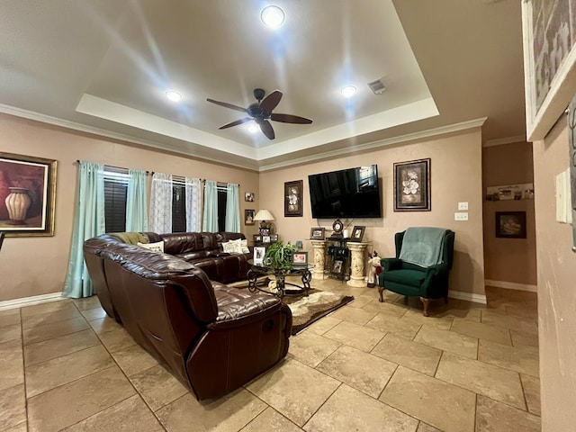 living room with a raised ceiling, ceiling fan, and crown molding