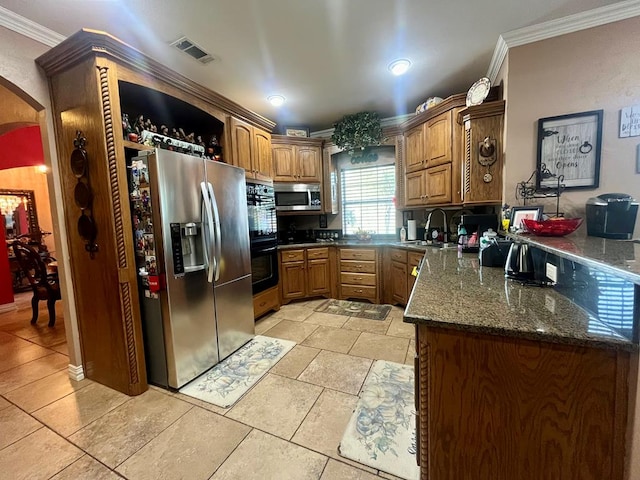 kitchen featuring sink, crown molding, appliances with stainless steel finishes, and dark stone counters