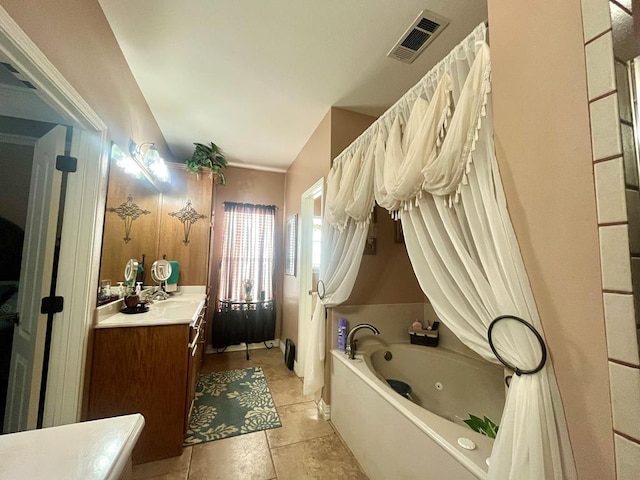 bathroom with tile patterned floors, a bathtub, and vanity