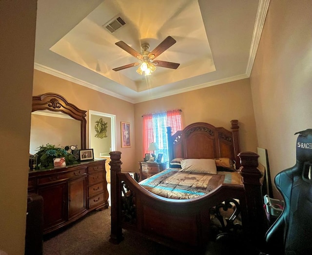 bedroom featuring a tray ceiling, ceiling fan, dark colored carpet, and ornamental molding