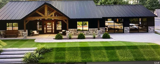 rear view of house with stone siding, metal roof, and a standing seam roof