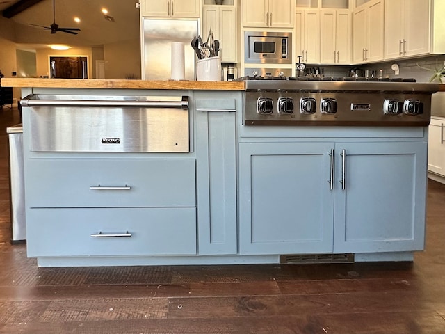 kitchen with white cabinetry, stainless steel microwave, ceiling fan, and dark hardwood / wood-style flooring