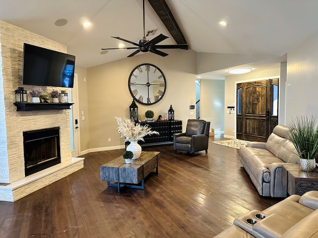 living room featuring vaulted ceiling with beams, a stone fireplace, dark hardwood / wood-style floors, and ceiling fan