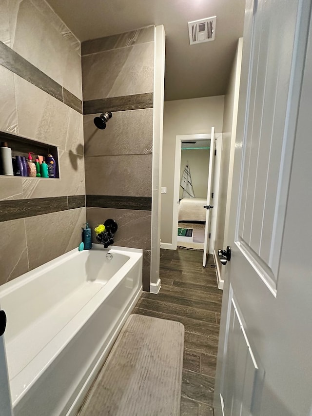 bathroom featuring hardwood / wood-style flooring and bathtub / shower combination