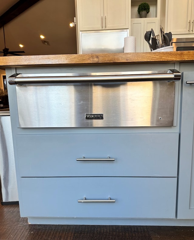 details with dark wood-type flooring and white cabinets