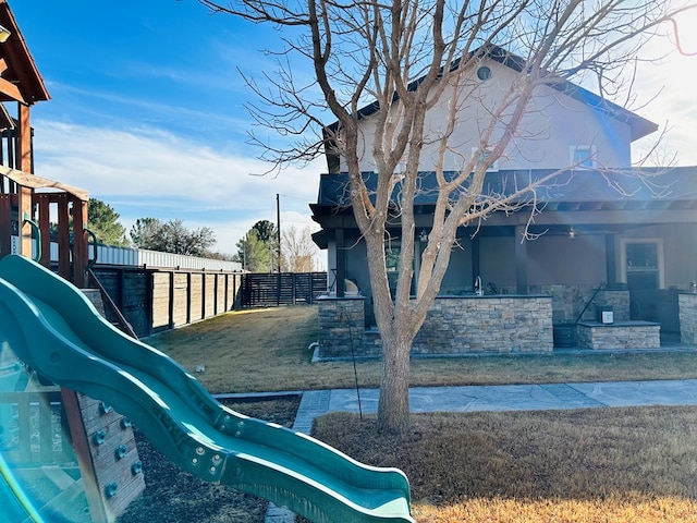 view of playground with a lawn