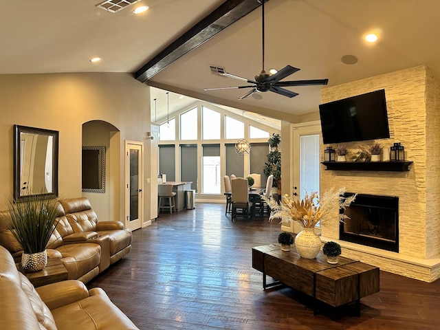 living room featuring a fireplace, dark wood-type flooring, lofted ceiling with beams, and ceiling fan