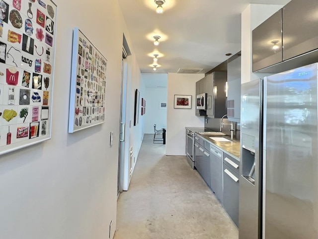 kitchen featuring gray cabinetry, sink, and appliances with stainless steel finishes