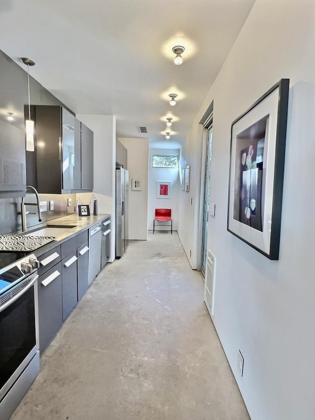 kitchen with appliances with stainless steel finishes, hanging light fixtures, and sink