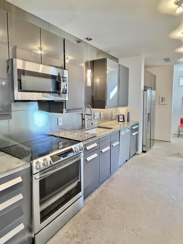 kitchen with hanging light fixtures, tasteful backsplash, sink, and stainless steel appliances