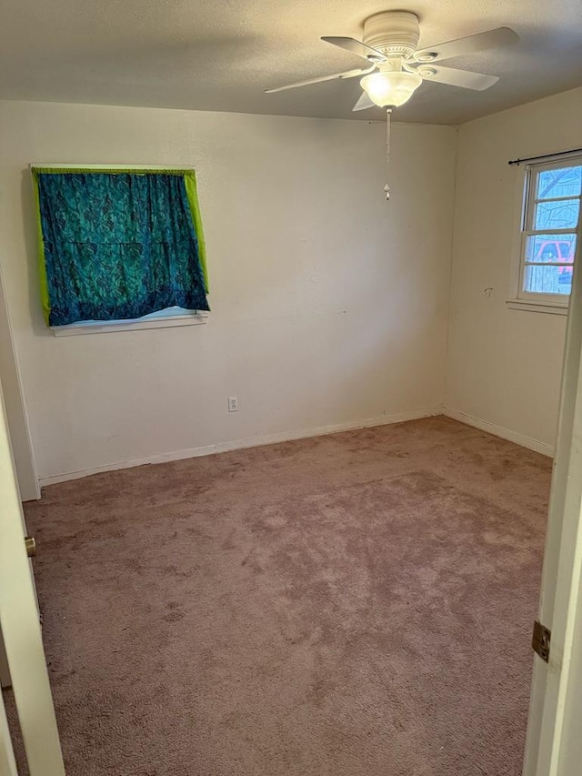 carpeted spare room with a ceiling fan, a textured ceiling, and baseboards