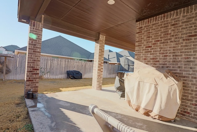 view of patio with a trampoline and a fenced backyard