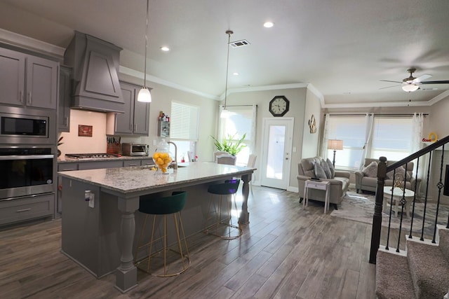 kitchen with visible vents, gray cabinets, appliances with stainless steel finishes, and premium range hood