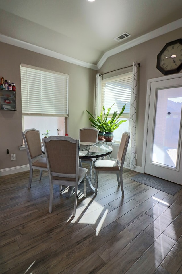 dining area featuring crown molding, wood finished floors, visible vents, and baseboards