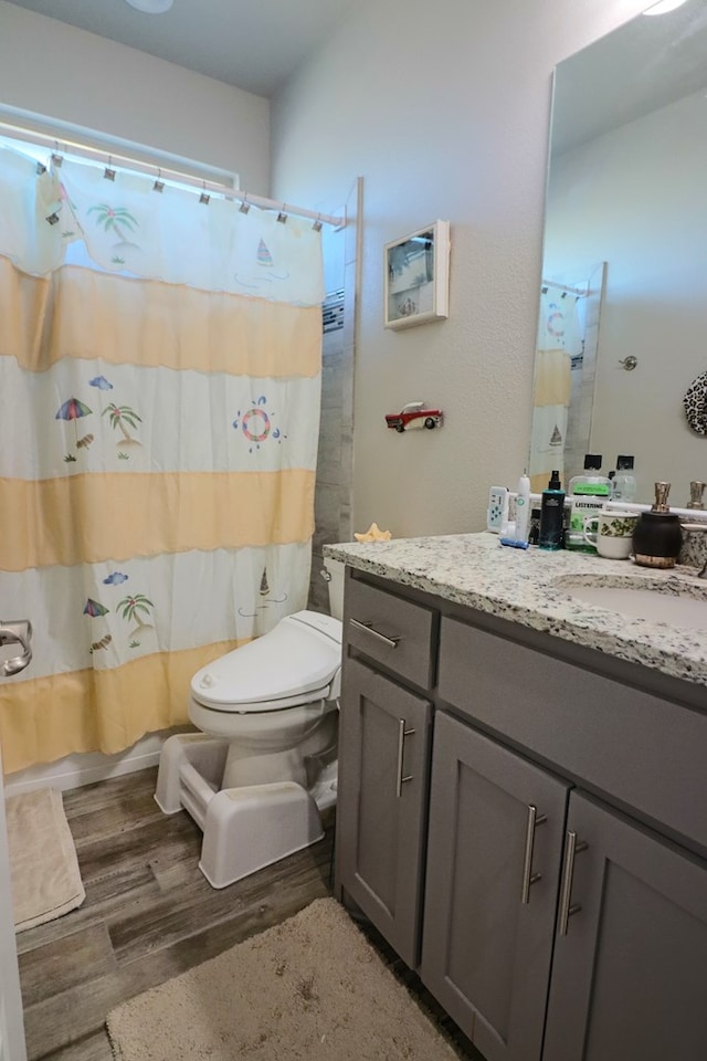 bathroom featuring vanity, shower / tub combo, toilet, and wood finished floors