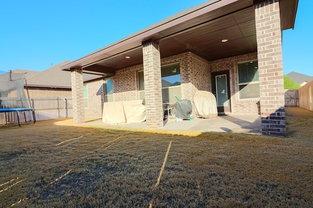 back of house featuring a patio, a fenced backyard, and brick siding