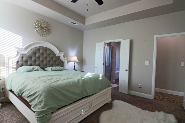 carpeted bedroom featuring a ceiling fan, baseboards, visible vents, and connected bathroom